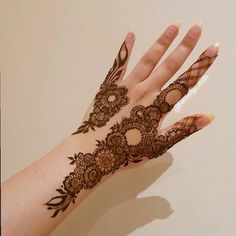 a woman's hand with henna tattoos on it