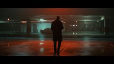 a man standing in the middle of a parking garage with his back turned to the camera