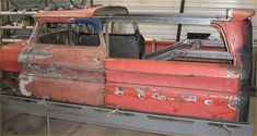 an old rusted truck sitting in a garage