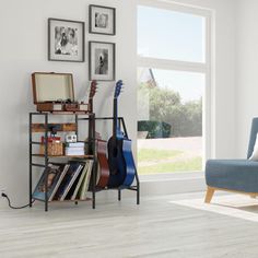 a living room filled with furniture and a guitar on a book shelf next to a window