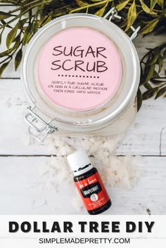 sugar scrub in a small jar next to some plants and cotton floss on a white wooden table