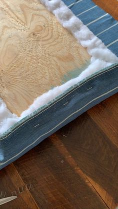 a pair of scissors and some fabric on a wooden table with an old piece of cloth