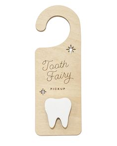 a wooden tooth shaped bottle opener with the words tooth fairy on it's front