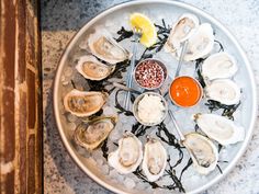 oysters on an ice tray with dipping sauce