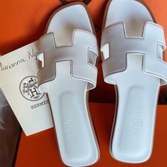 Hi Everyone! Oran Sandal Blanc Bnib Size 35 White All My Receipt. Ready To Ship. Thank You Beautiful Ladies. Have A Great Day. Sandal Hermes, Hermes Slippers Women, Hermes Sandals Heels, Hermes Oran White, White Hermes Sandals, Hermes H Sandals, Slippers Outfit Casual, Hermes White Sandals, Oasis Shoes