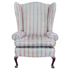 an upholstered chair with striped fabric on the back and arms, in front of a white background