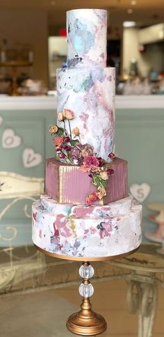 a multi - tiered wedding cake with flowers on the top is sitting on a table