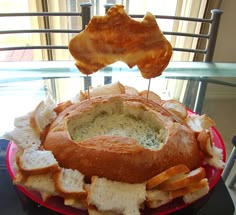 a plate with bread and dip in it sitting on a table next to a window