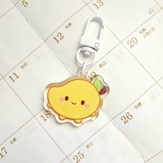 a keychain with a cartoon character on it sitting on top of a calendar