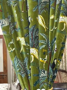 green curtains with giraffes and palm leaves on them in a living room