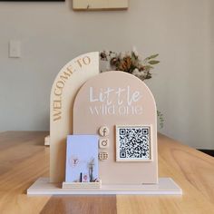 a wooden table with a sign and pictures on it that says welcome to little wild one