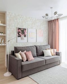 a living room with a gray couch and two pictures on the wall next to it