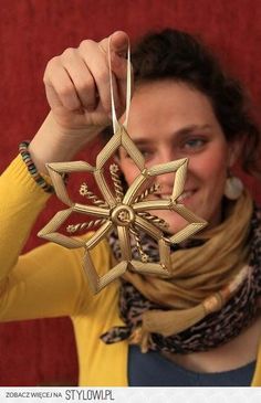 a woman wearing a scarf holding up a star ornament in front of her face