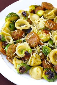 a white plate topped with pasta and brussels sprouts