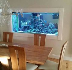 a dining room table and chairs with an aquarium in the window