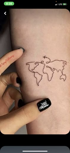 a woman's arm with a tattoo on it that has the world map drawn on it