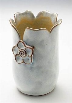 a white vase with a brown flower on it