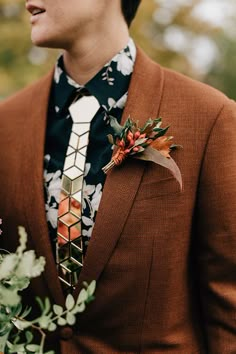 a man in a suit and tie with flowers on his lapel flower boutonniere