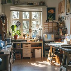 a home office with lots of clutter on the desks and shelves in front of large windows