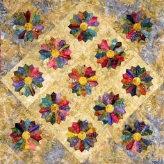 a quilted wall hanging with colorful flowers on it