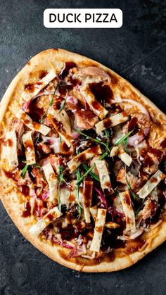 a pizza topped with lots of toppings sitting on top of a black countertop