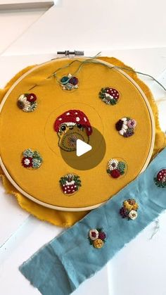 a video demonstrating how to sew an embroidered mushroom on a yellow piece of fabric