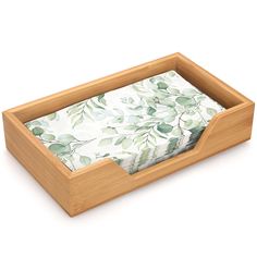 a wooden tray with green leaves on it and a white sheet in the bottom drawer