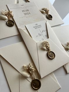 wedding stationery with buttons and flowers on them