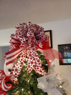 a christmas tree decorated with red and white bows