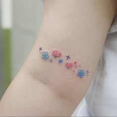 a woman's arm with flowers and stars on the left side of her arm