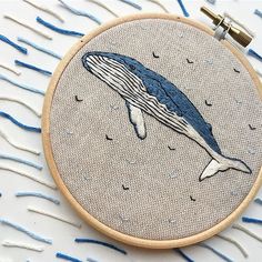 a blue whale in the water is embroidered on a hoop