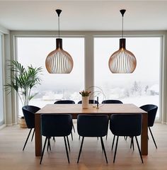 an image of a dining room setting with modern furniture and large windows in the background