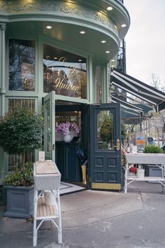 an outside view of a restaurant with tables and chairs in front of the entrance door