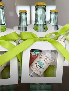 four bottles with lemonade and limes in them are tied up to a ribbon