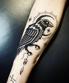 a black and white tattoo on the arm of a person with a bird on it