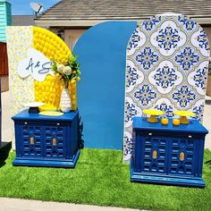 two blue and yellow chests sitting on top of green grass next to each other in front of a building