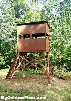 a large wooden structure in the middle of a forest with trees behind it and text overlay that reads how to build a tree house out of wood