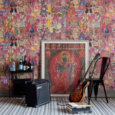 a guitar, amp and other musical instruments sit in front of a colorful wallpaper