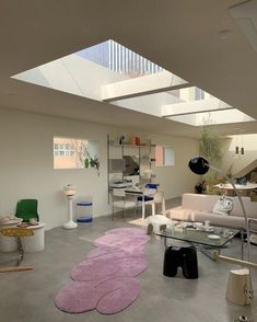 a living room filled with furniture and a skylight in the middle of it's ceiling