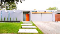 a modern house with grass and steps leading to the front door