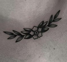 a black and white photo of a woman's chest with flowers on the side