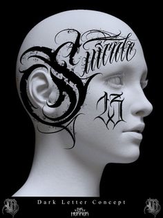 a white mannequin head with black lettering on it's face and the word tattoo written in cursive ink