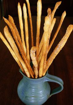 a blue pitcher filled with french fries on top of a wooden table