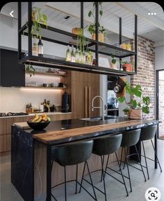 a kitchen with an island in the middle and lots of plants growing on top of it