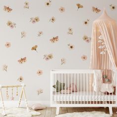 a baby's room with flowers on the wall and a crib next to it