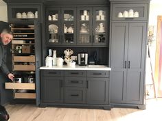 a man standing in front of a kitchen counter with lots of cupboards on it