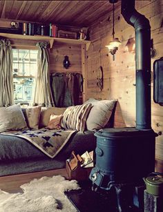 a living room filled with furniture and a fire place in front of a wooden wall