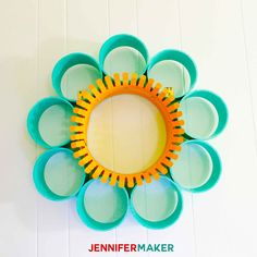 an orange and blue flower shaped mirror on the wall