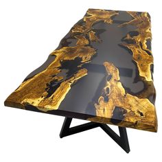 a wooden table with black and gold paint on it