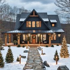 a house that is in the snow with christmas trees around it and lights on each side